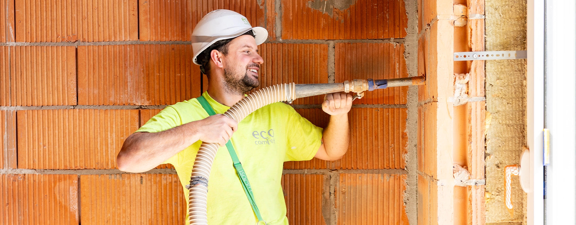Technieker van ECO Comfort blaast URSA Pure Floc in voor spouwmuurisolatie.